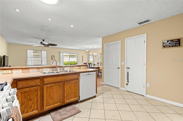 kitchen featuring sink, ceiling fan with notable chandelier, a textured ceiling, and white appliances