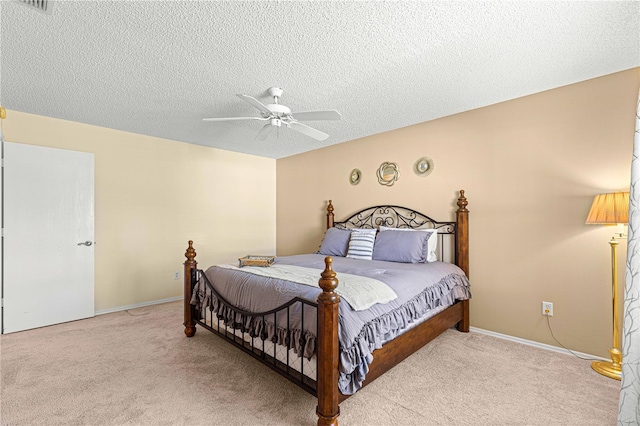 bedroom featuring ceiling fan, a textured ceiling, and light colored carpet