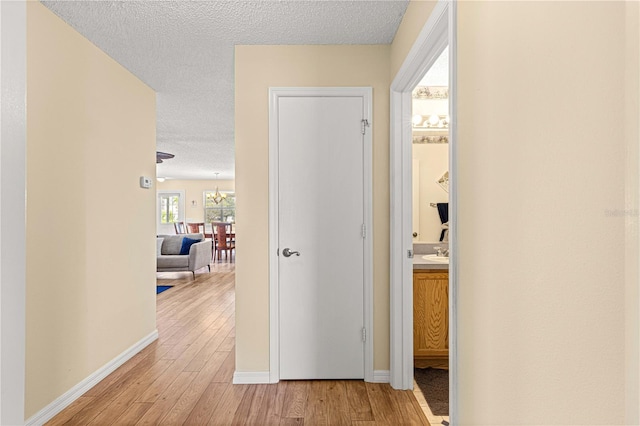 corridor with light hardwood / wood-style flooring and a textured ceiling