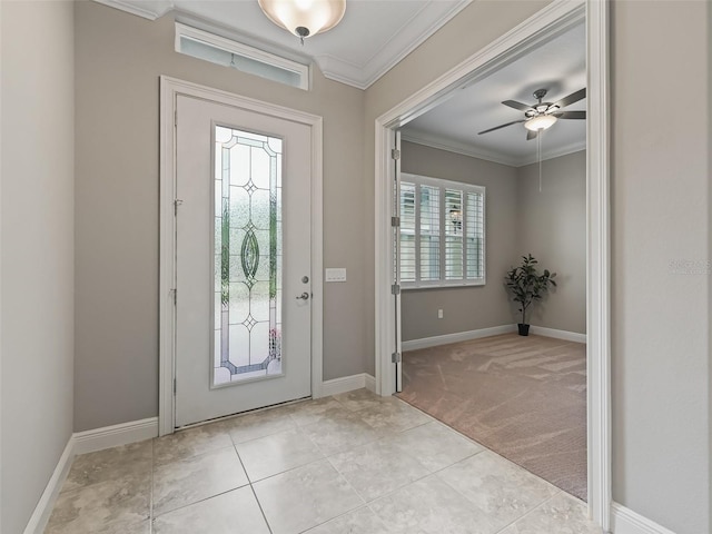 entrance foyer with ceiling fan, light colored carpet, and ornamental molding