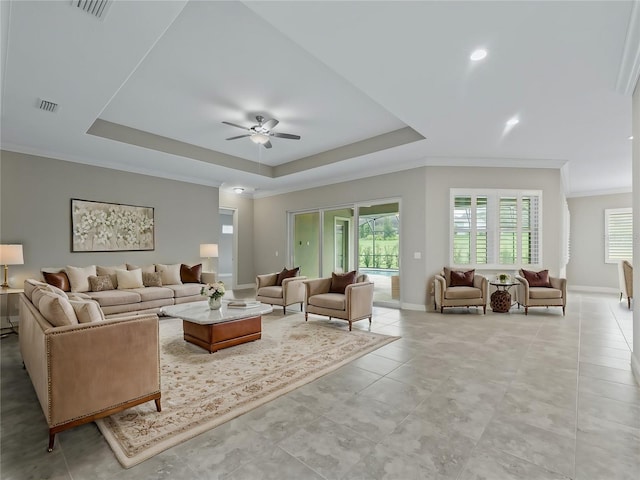 living room featuring ceiling fan, a raised ceiling, and crown molding