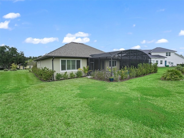 back of house featuring a yard and glass enclosure