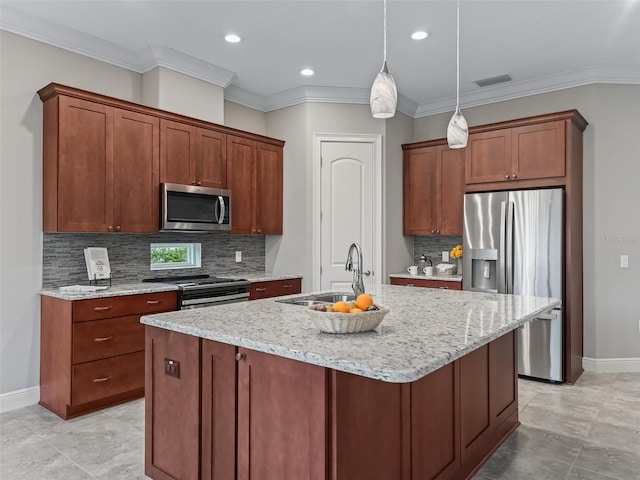 kitchen featuring appliances with stainless steel finishes, light stone counters, crown molding, sink, and a center island with sink