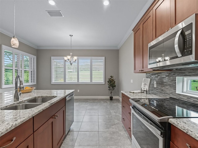 kitchen with stainless steel appliances, light stone counters, a notable chandelier, and sink