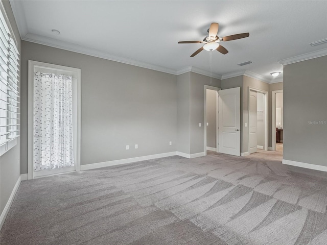 carpeted empty room featuring crown molding, plenty of natural light, and ceiling fan