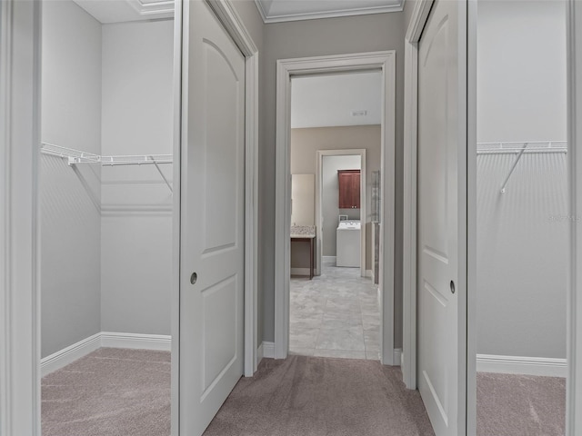 hall featuring light carpet, washer / clothes dryer, and ornamental molding