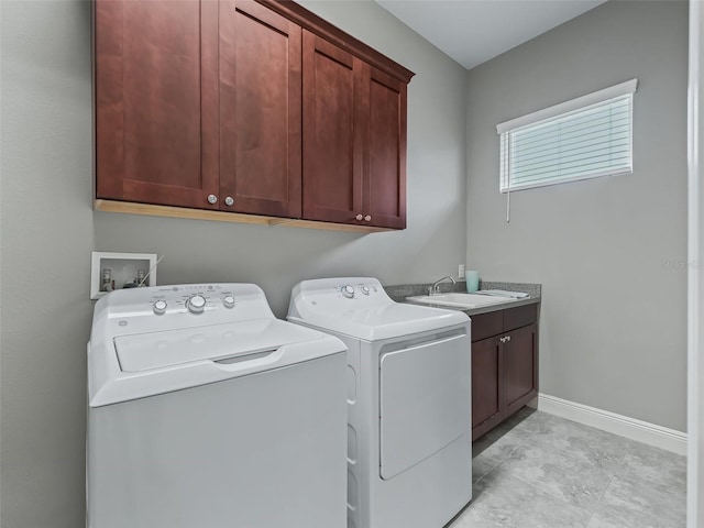 washroom with washing machine and clothes dryer, sink, and cabinets