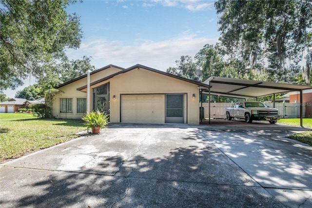 ranch-style home with a garage, a front lawn, and a carport