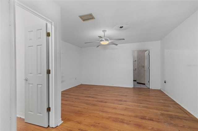 empty room with ceiling fan and light hardwood / wood-style floors