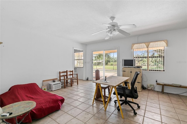 tiled office space featuring ceiling fan and a textured ceiling