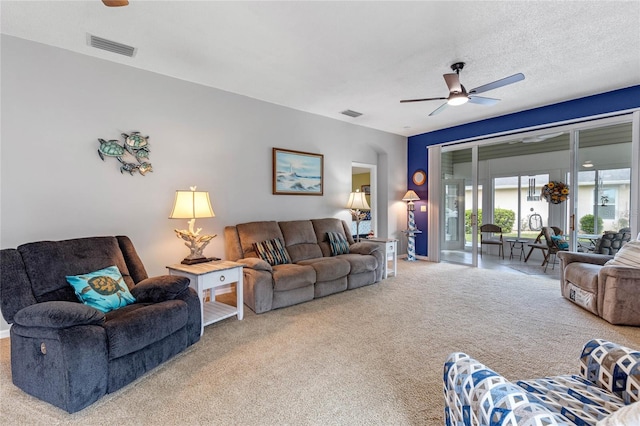 carpeted living room featuring a textured ceiling and ceiling fan