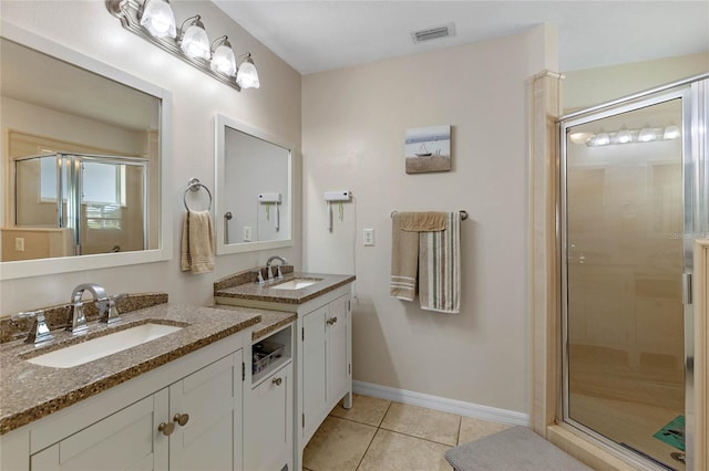 bathroom with walk in shower, vanity, and tile patterned floors