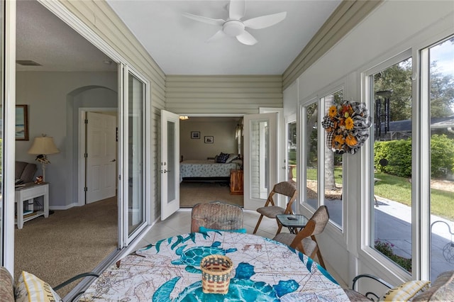 sunroom / solarium featuring french doors and ceiling fan