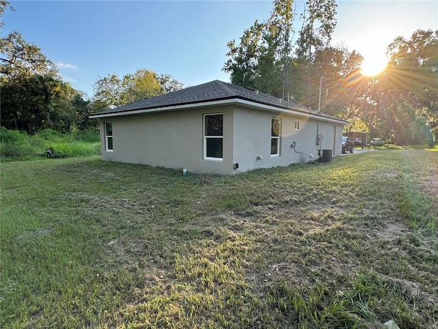 view of home's exterior featuring a yard and central AC