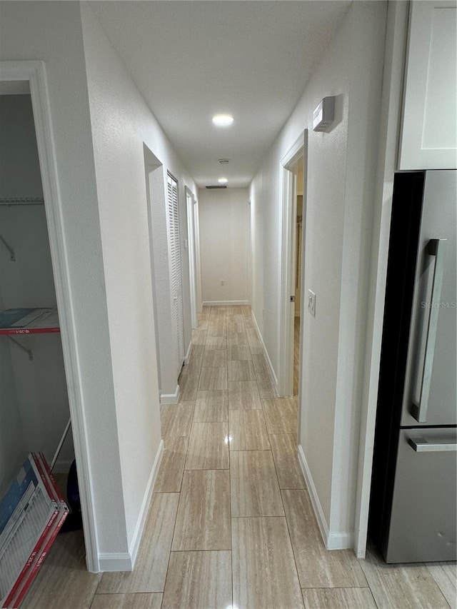 hallway with light hardwood / wood-style floors