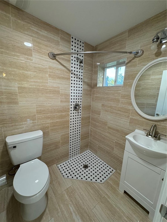 bathroom featuring vanity, tile walls, toilet, and tiled shower