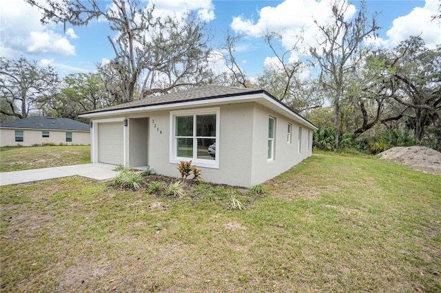 view of front of property with a shingled roof, a front yard, concrete driveway, and stucco siding