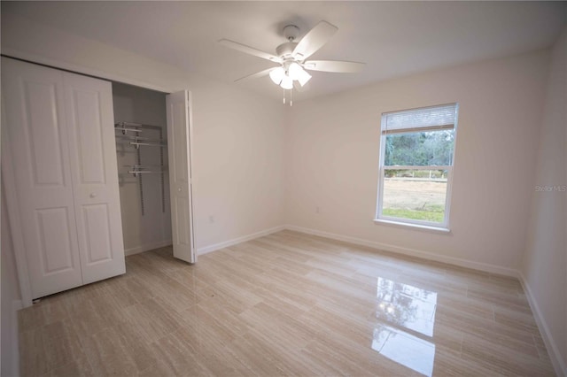 unfurnished bedroom with light wood-style floors, a closet, ceiling fan, and baseboards