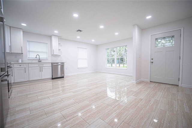 kitchen featuring light countertops, visible vents, white cabinetry, a sink, and dishwasher