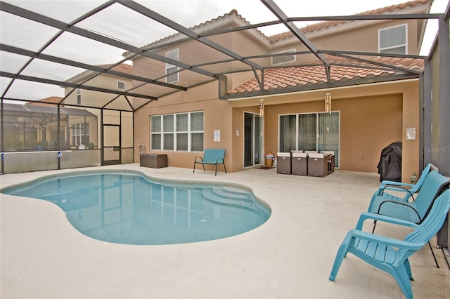 view of swimming pool featuring glass enclosure and a patio