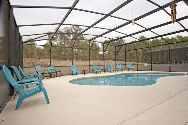 view of swimming pool featuring a lanai and a patio