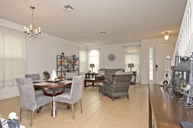 dining room with a notable chandelier, light tile patterned floors, and a wealth of natural light