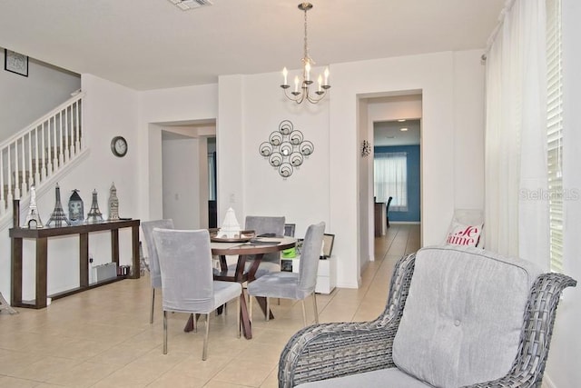 dining room with light tile patterned floors, a chandelier, and a wealth of natural light