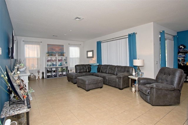 living room featuring a textured ceiling and light tile patterned flooring