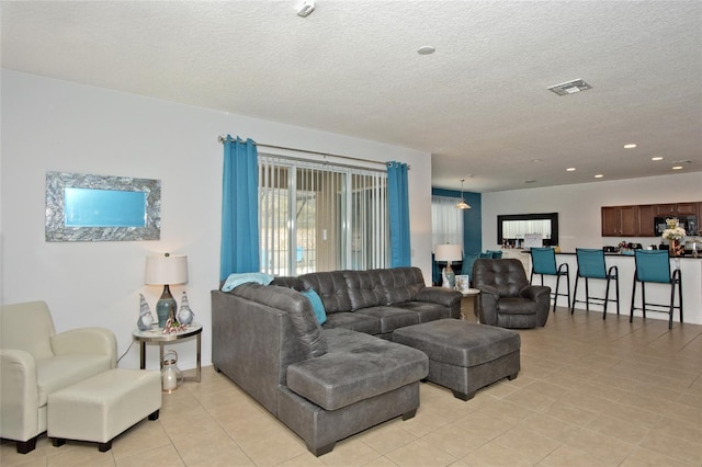 living room with a textured ceiling and light tile patterned floors