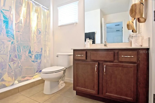 bathroom featuring tile patterned flooring, walk in shower, vanity, and toilet