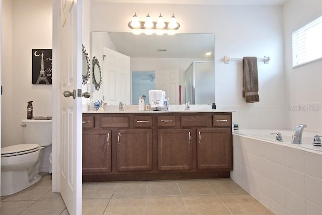 full bathroom featuring shower with separate bathtub, tile patterned floors, vanity, and toilet