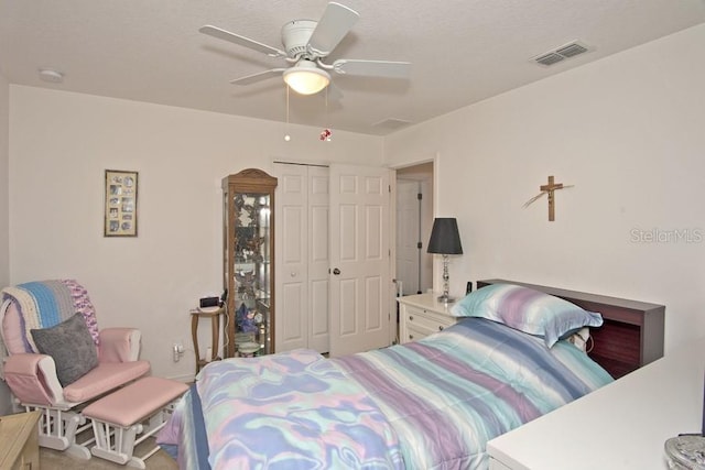 bedroom featuring a textured ceiling, ceiling fan, and a closet