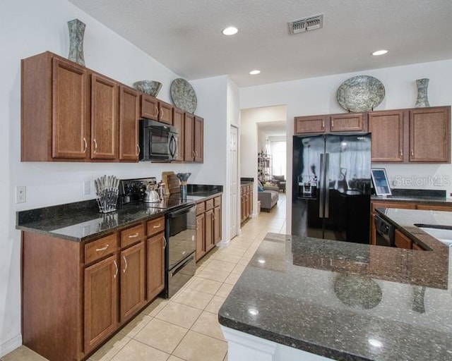 436 Orange Cosmos Blvd, Davenport, FL 33837 - kitchen featuring black appliances, light tile patterned floors, dark stone countertops, recessed lighting, and brown cabinets
