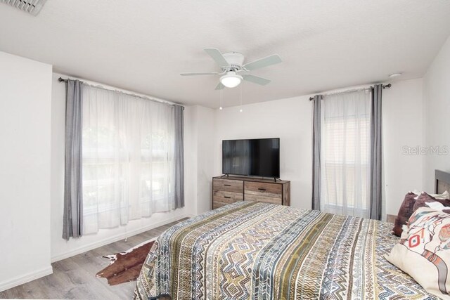 436 Orange Cosmos Blvd, Davenport, FL 33837 - bedroom featuring wood finished floors, a ceiling fan, and baseboards