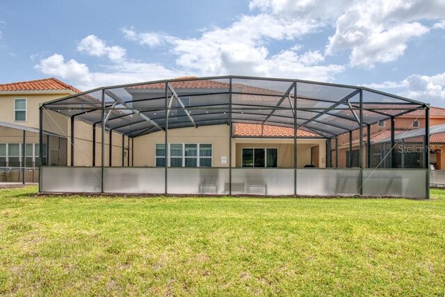 436 Orange Cosmos Blvd, Davenport, FL 33837 - rear view of property with stucco siding and a lawn