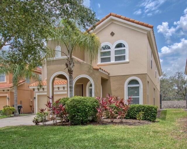 436 Orange Cosmos Blvd, Davenport, FL 33837 - mediterranean / spanish home featuring stucco siding, a front yard, driveway, an attached garage, and a tiled roof