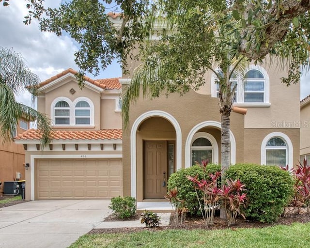 436 Orange Cosmos Blvd, Davenport, FL 33837 - mediterranean / spanish home featuring central AC unit, stucco siding, and an attached garage