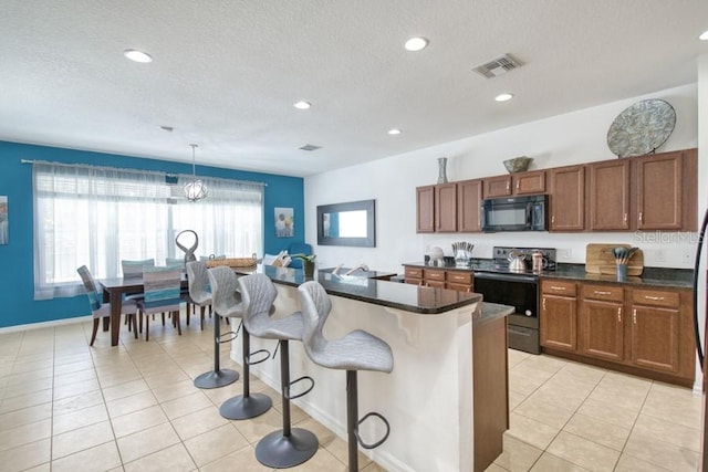 436 Orange Cosmos Blvd, Davenport, FL 33837 - kitchen with black appliances, dark countertops, a textured ceiling, a breakfast bar area, and brown cabinetry