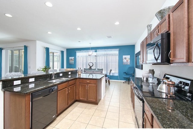 436 Orange Cosmos Blvd, Davenport, FL 33837 - kitchen with black appliances, a sink, light tile patterned floors, recessed lighting, and dark stone countertops