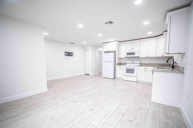 kitchen featuring light stone counters, white appliances, a sink, visible vents, and white cabinetry