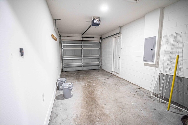 garage with baseboards, concrete block wall, electric panel, and a garage door opener