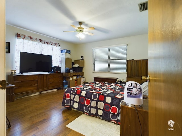 bedroom with dark hardwood / wood-style flooring and ceiling fan