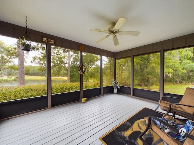 unfurnished sunroom featuring a water view and ceiling fan