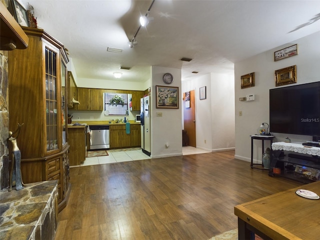 kitchen with light hardwood / wood-style flooring, track lighting, dishwasher, and white fridge