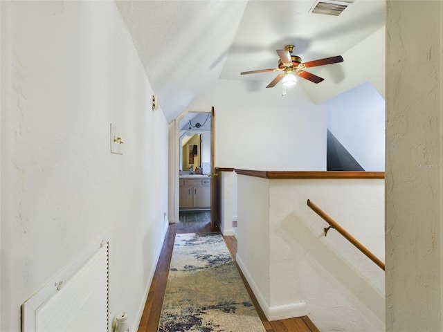 hallway featuring vaulted ceiling and dark hardwood / wood-style floors