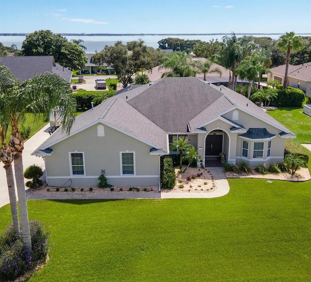 ranch-style house featuring a water view and a front lawn