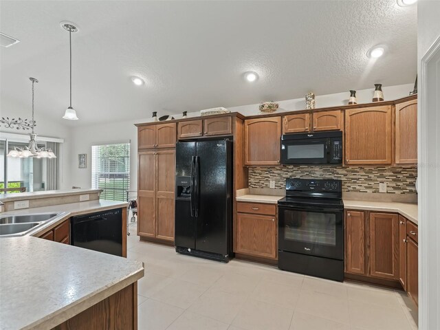 kitchen with hanging light fixtures, vaulted ceiling, black appliances, an inviting chandelier, and sink