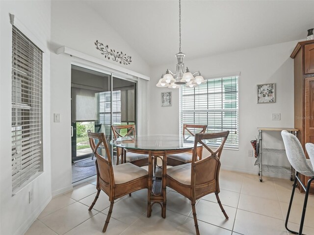 tiled dining area with an inviting chandelier, lofted ceiling, and a healthy amount of sunlight