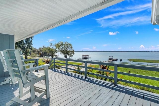 wooden terrace featuring a water view and a yard