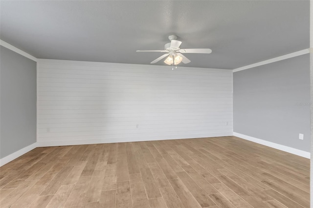 spare room with light wood-type flooring, ornamental molding, and ceiling fan